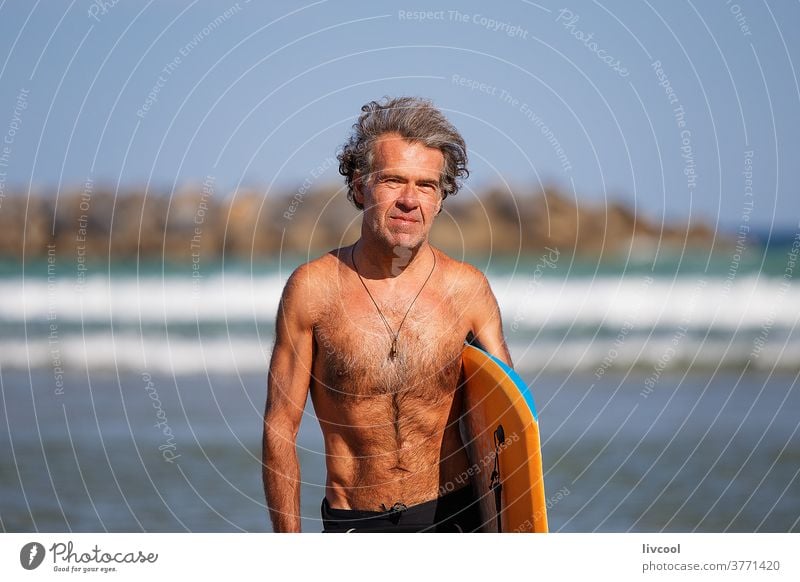 reifer Surfer am Strandufer, zurriola-spain Senior Mann praktizieren Wasser Menschen Erwachsener Brandung Holzplatte Surfbrett Neopren Surfboarderin Lifestyle