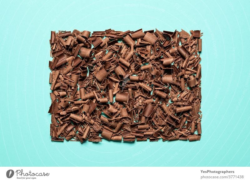 Schokoladenstücke auf blauem Hintergrund isoliert gestapelt. Draufsicht auf gehackte Schokolade backen bitter braun Schokoladenraspeln Weihnachten Stücke