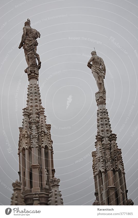 Filigrane Spitzen und Türmchen mit Stuckarbeiten und Figuren auf dem Dach des Mailänder Domes. Himmel grau Turm Kunstwerk Baukunst Kirche Baustil Gotik gotisch