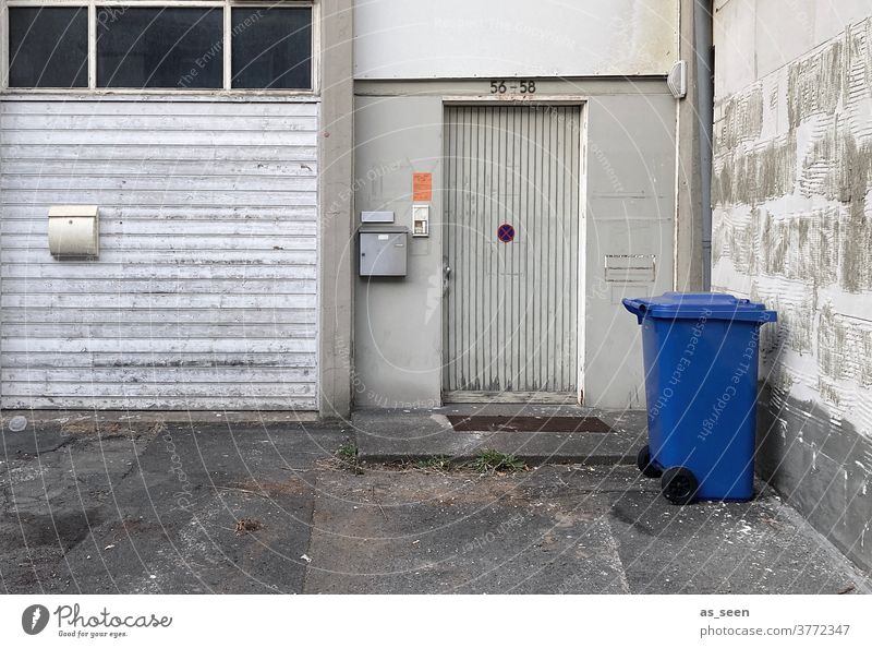 Unbekannt verzogen - Eingang mit blauer Mülltonne alt Briefkasten Tür grau Einfahrt Papiermüll Grauschattierungen im Stich lassen Haus Außenaufnahme