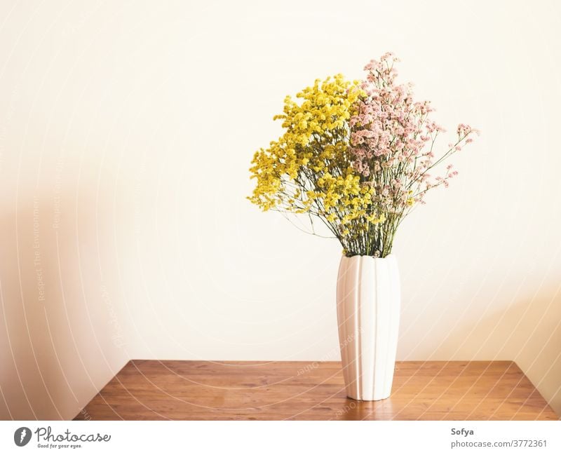 Getrocknete rosa und gelbe Blumen in weißer Vase Herbst getrocknet Innenbereich Saison Blumenstrauß Ordnung Dekor heimwärts natürlich Erntedankfest Wand Farbe