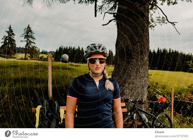 Portrait einer Radfahrerin auf einer Radtour im Grünen radtour radfahrerin mountainbike natur landschaft baum wiese bayern helm sonnenbrille sportklamotten