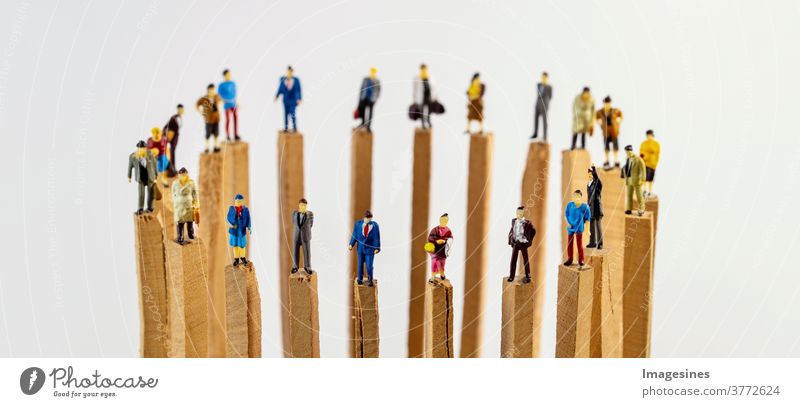 Soziale Distanzierung. Ein Kreis von Miniatur Spielzeug Menschen auf Holzpfählen die Abstand halten Soziale probleme Covid-19 Teamwork Konzepte Reduzierung