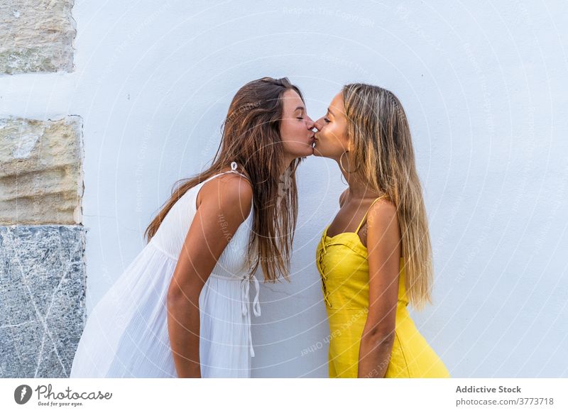 Junge Freundinnen küssen in der Nähe der Wand Frauen Paar Kuss lesbisch romantisch Partnerschaft Liebe Zusammensein Zuneigung Angebot tausendjährig Glück
