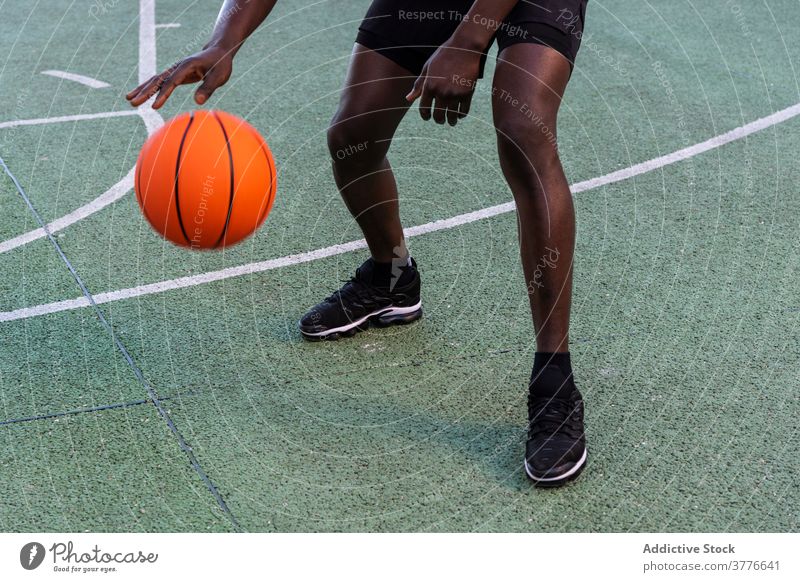 Konzentrierter schwarzer Mann spielt Basketball auf dem Platz Spieler spielen Ball Sportpark Spielplatz Taktik Fokus männlich Afroamerikaner ethnisch modern