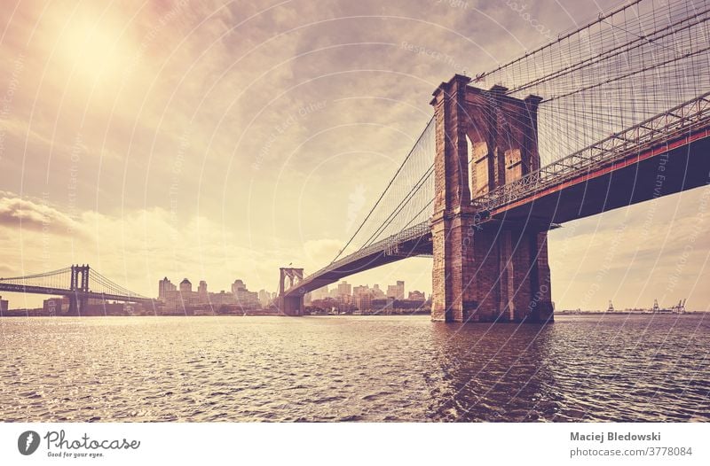 Vintage getöntes Bild der Brooklyn Bridge gegen die Sonne, New York. New York State Großstadt retro altehrwürdig Gebäude Stadtbild Sonnenuntergang Fluss Skyline