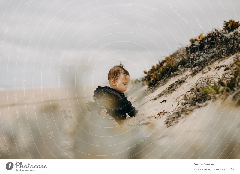 Kleinkind spielt am Sandstrand Strand Stranddüne Herbst authentisch Landschaft Düne Natur Meer Tag Farbfoto Außenaufnahme Ferien & Urlaub & Reisen Küste Umwelt