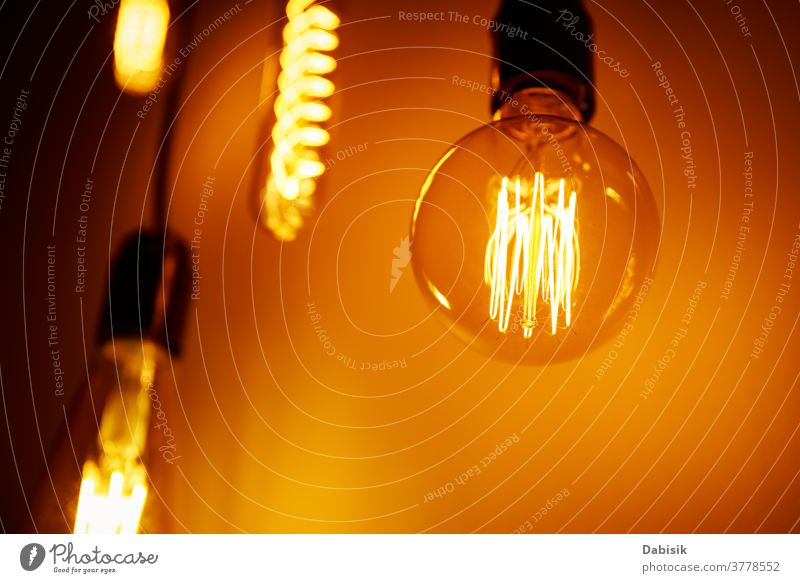 Satz einer Vintage-Glühbirne auf orangem Hintergrund, Weichzeichner. Glühende Edison-Glühbirne Knolle Licht altehrwürdig Lampe Design weiß kreativ Konzept Idee
