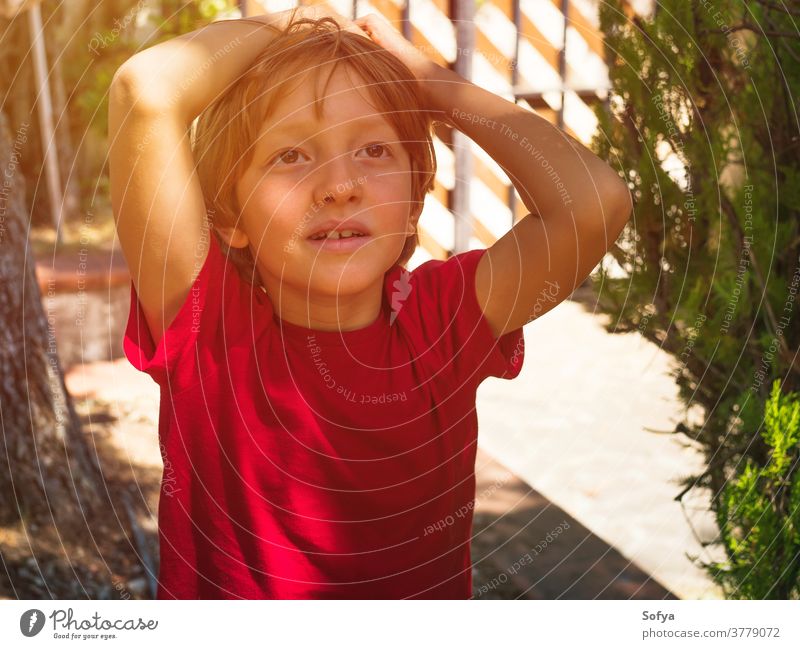 Kleiner Junge spielt im Sommer im Freien Lifestyle Kind authentisch Hinterhof Freiheit Natur Gesicht Lächeln Sonne Spaß wenig Porträt niedlich Freude blond