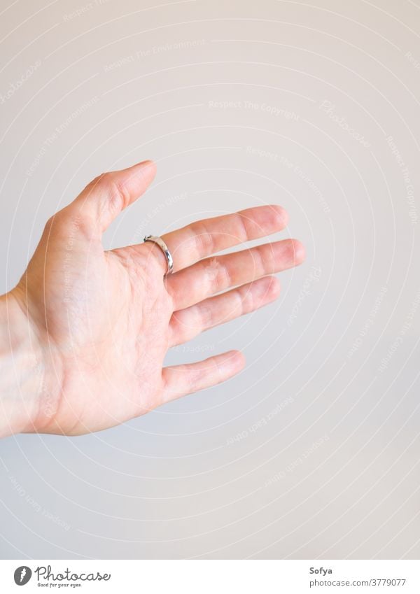 Verlängerte Frauenhand mit offener Handfläche erweitert grau Wand Hintergrund Hilfsbereitschaft Ring abstrakt geben durchhalten Nahaufnahme gestikulieren