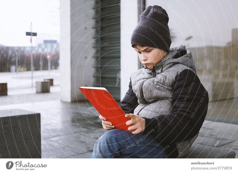 Junge schaut mit frustriertem Gesichtsausdruck auf Tablet-PC Kind tablet Computer Tablet Computer tablet-pc spielen Spiel Technik & Technologie Menschen digital