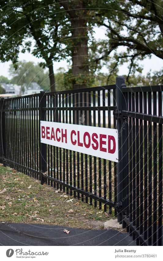 Schild "Strand geschlossen" auf schwarzem Metallzaun Zeichen zugeklappt Schilder & Markierungen Hinweisschild Warnschild rot rote Buchstaben Vorsicht fallen