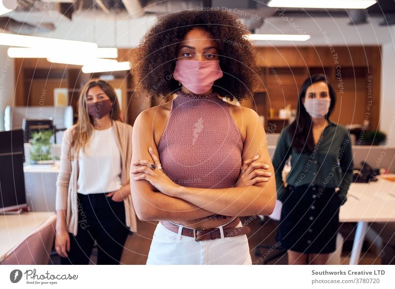 Porträt eines weiblichen Geschäftsteams, das während der Covid-19-Pandemie in einem Großraumbüro Gesichtsmasken trug Business Geschäftsfrauen Team
