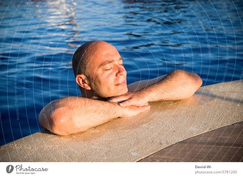 Sonnenbad - Mann lässt sich im Pool von der Sonne bescheinen sonnig pool genießen Urlaub Wellness Sonnenstrahlen ruhe Erholung