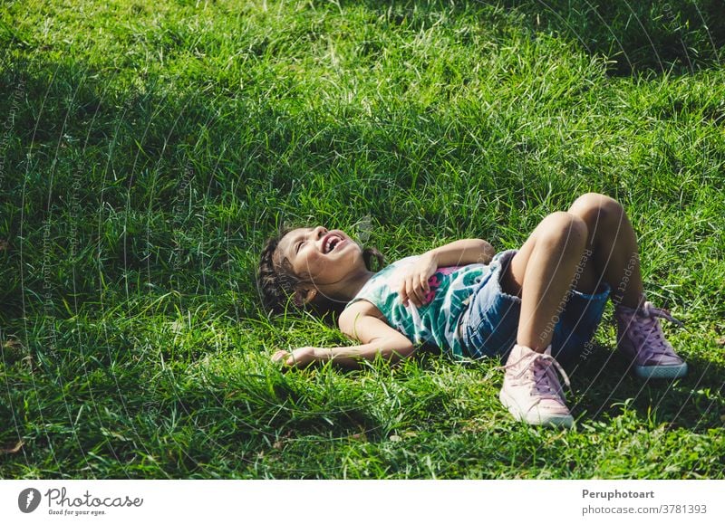 Kleines Mädchen ruht im Gras und lächelt an einem sonnigen Tag Kind Lügen Natur grün Lächeln Frühling Kinder sich[Akk] entspannen Feld Sonne Wiese Person Blume
