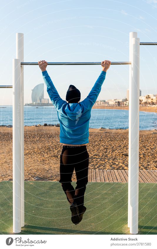 Starker Mann trainiert auf Bar in der Nähe von Meer Training hochziehen Strand MEER Fitness Übung sportlich aktiv männlich passen Gesundheit stark Sportpark