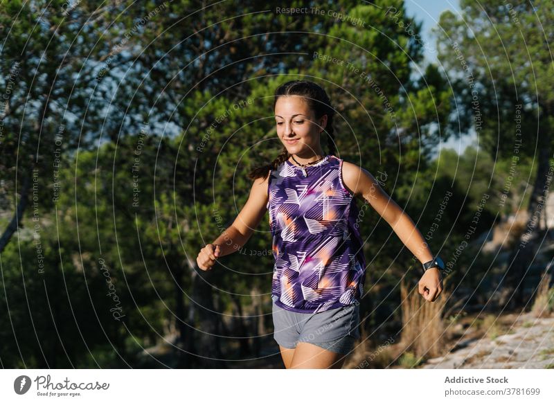 Aktive Frau läuft auf Pfad im Wald Nachlauf laufen Berge u. Gebirge aktiv Training Sport Athlet positiv jung Natur Fitness Lifestyle Sportkleidung
