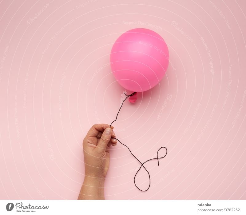 weibliche Hand, die einen aufgeblasenen rosa Luftballon auf rosa Hintergrund hält Air Arme Ball Ballon blanko Nahaufnahme Frau gefüllt Schwimmer Helium Halt