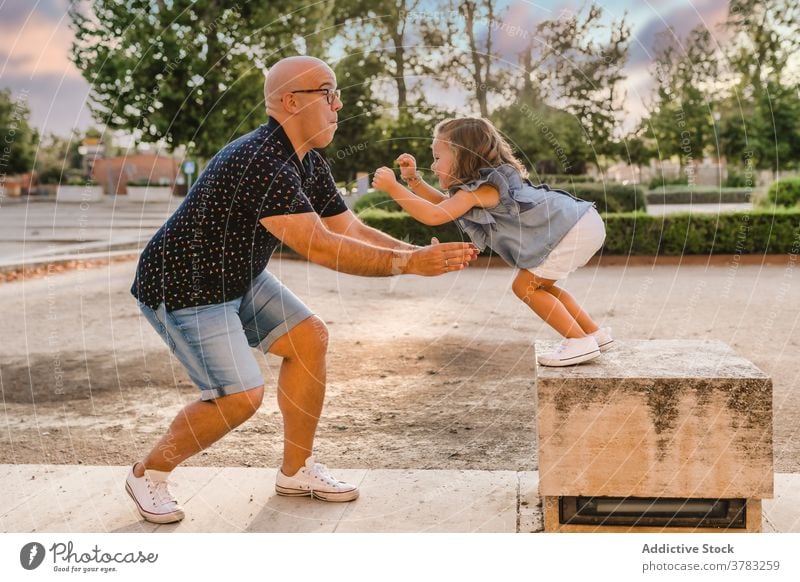 Mann spielt mit Mädchen im Park im Sommer Vater Tochter Spaß haben Zusammensein spielerisch springen fangen unterhalten Großstadt Kind Bonden Eltern spielen