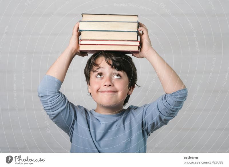 glückliches Kind mit Büchern auf dem Kopf Buch Bildung Weisheit zurück zur Schule Kindheit Intelligenz Wissen lernen Schüler Denken genial Schuljunge Lächeln