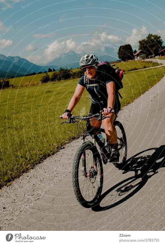 Mountainbikerin in den Allgäuer Alpen mountainbike mtb fahrrad sport sommer sonne berge alpen allgäu radtour radreise rucksack junge frau sonnebrille helm