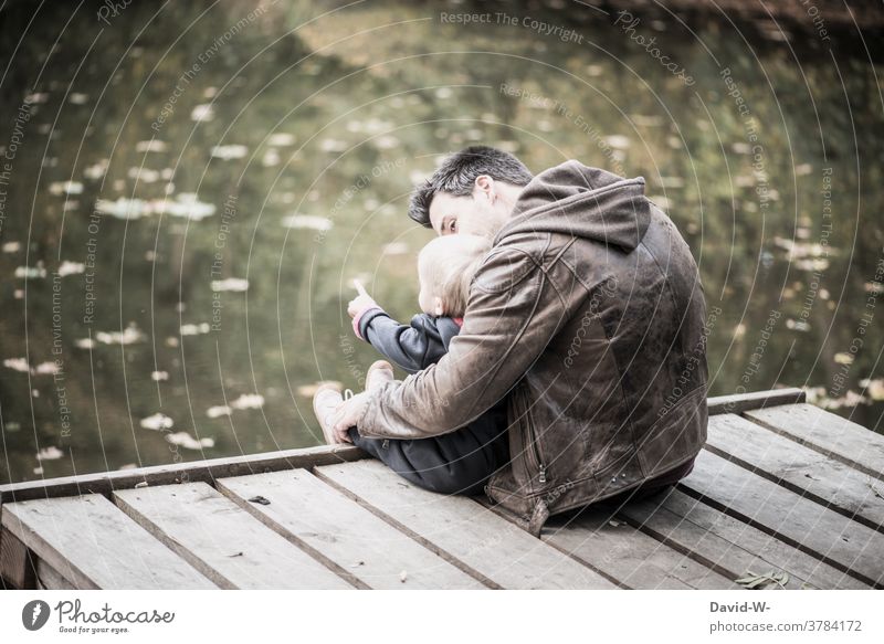 Vater Und Kind Sitzen Gemeinsam Auf Einem Steg Am See Ein Lizenzfreies Stock Foto Von Photocase