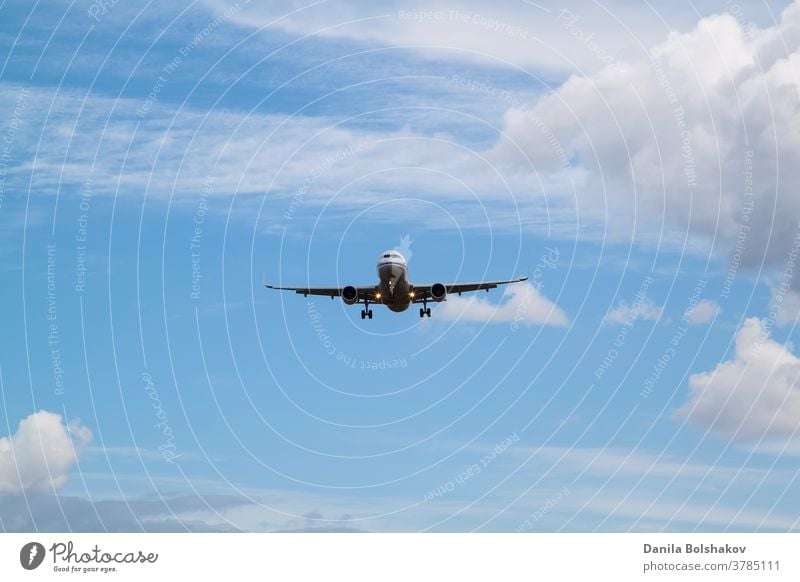 weißes Passagierflugzeug kommt zur Landung mit natürlichem Hintergrund aus weißen Wolken und blauem Himmel Air Fluggerät Fluggesellschaft Verkehrsflugzeug