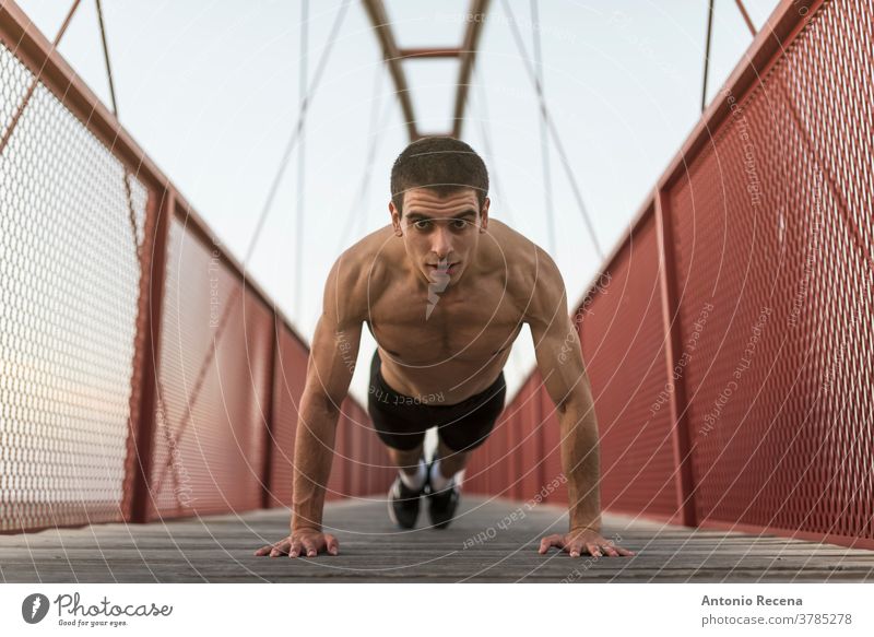 Erwärmung der Läufer: Junger Mann trainiert Push-Ups auf der roten Brücke laufen stark passen Fitness Steg Fußweg Männer männlich junger Erwachsener eine Person