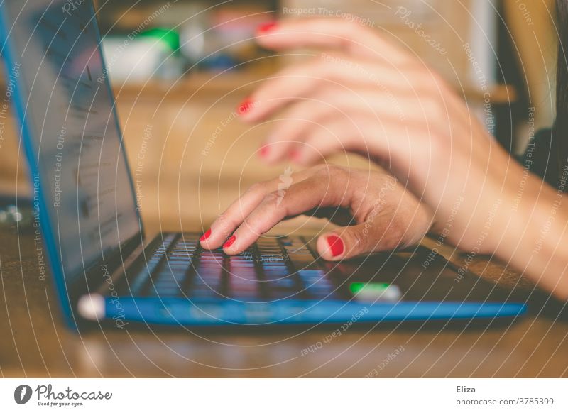 Die Hände einer Frau tippen etwas auf dem Notebook. Home Office. Tastatur Business online schreiben arbeiten weiblich Internet blau zuhause Tisch