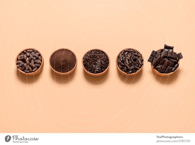 Kakao- und Schokoladenzutaten in Schalen. Kakaobohnen und Schokoladenmischung in der Draufsicht obere Ansicht ausgerichtet Sortiment Hintergrund backen beige
