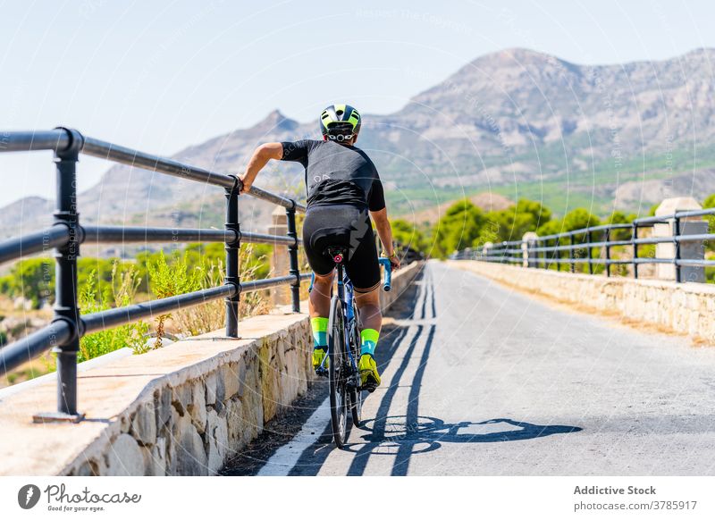Sportlicher Radfahrer ruht sich während der Fahrt auf der Bergstraße aus Fahrrad Mitfahrgelegenheit Berge u. Gebirge Straße ruhen aktiv Training Lifestyle