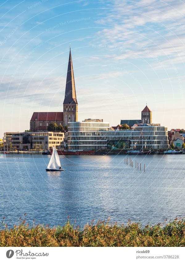 Blick auf die Hansestadt Rostock mit Petrikirche, Nikolaikirche und Silohalbinsel Segelboot Warnow Fluss Stadthafen Mecklenburg-Vorpommern Tourismus Schiff Boot