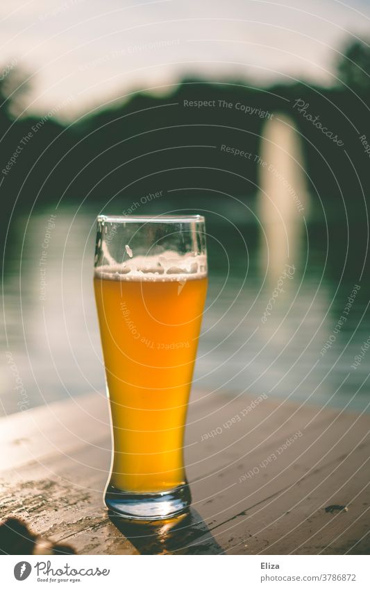Eine Weißbier ohne Schaumkrone im Biergarten an einem See schlecht eingeschenkt Glas Halbe draußen Wasser Bayern Weizen Alkohol Getränk Biertisch gutes Wetter