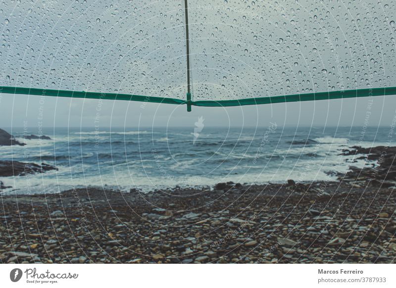 Blick auf die Küste mit Regenschirm mit Regentropfen Wassertropfen Szene niemand allein Ufer dramatisch Tropfen Schutz Wellen Küstenlinie natürlich Gewitter