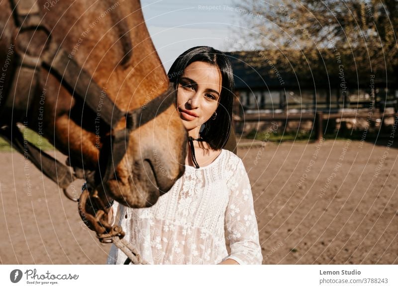 Nahaufnahme-Porträt einer Latina-Frau, die ein Pferd berührt Tier braun lateinamerikanisch Team Lächeln aktiv Dame Reiter Reiterin Eleganz Anzug Rennen