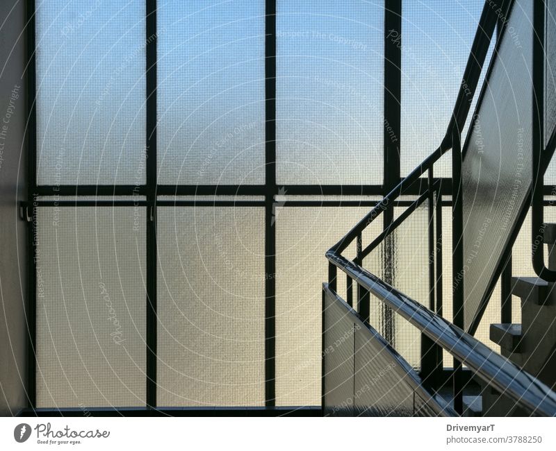 Fensterscheiben im Gebäudetreppenhaus mit blauem und gelbem Lichteinfall Treppenhaus Gang Saal Innenbereich Hintergrund Reling Geländer modern Metall Glas
