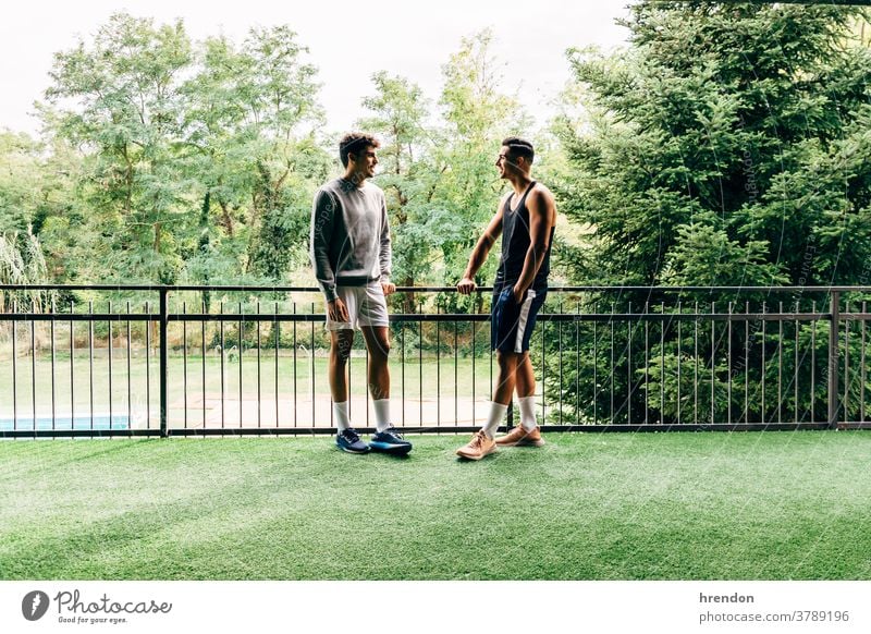 zwei in Sportkleidung gekleidete Männer unterhalten sich nach dem Training in der Turnhalle Menschen trainiert. Zwei Personen junger Erwachsener