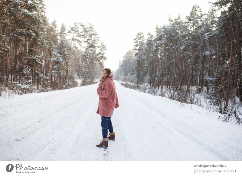 Junge hübsche stilvolle Frau, die sich im verschneiten Winterwald in Bewegung amüsiert. Mädchen Model Schnee Fröhlichkeit Lächeln Porträt stylisch Erwachsener