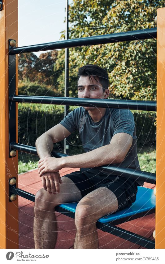Porträt eines jungen Mannes, der während seines Trainings eine Pause in einem modernen Fitnesspark macht calisthenics Pflege Kaukasier Gesundheit Lifestyle
