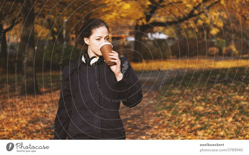 junge Frau, die unterwegs Kaffee zum Mitnehmen trinkt Hipster Lifestyle coffee to go trinken Menschen im Freien echte Menschen Herbst Getränk Park Mädchen