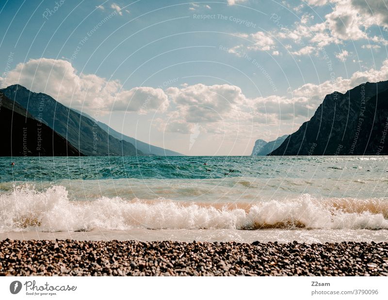 Wellen am Gardsee gardasee norditalien Torbole Urlaub wellen Wasser sehen Gewässer frisch Strang alpenländisch Berge wolken Himmel blau Ferien Sommer Sonne
