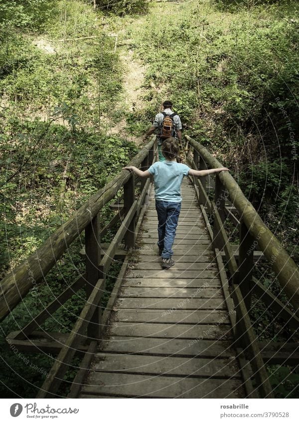 Zwischenräume | Kind geht hinter Vater über eine Holzbrücke Brücke folgen vertrauen festhalten gehen wandern spazieren miteinander nacheinander zusammen