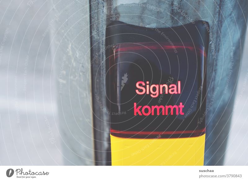 signal kommt Buchstaben Wort Straßenkreuzung Signal gelbes Kästchen Signalmast Straßenverkehr Verkehrswege Stadtverkehr warten rote Ampel Fußgängerübergang