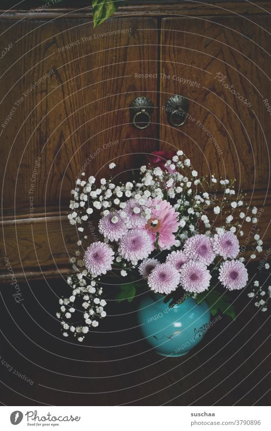 kleiner blumenstrauß in einer vase vor einem holzschränkchen Strauß Blumen Blumenstrauß Vase Pflückblumen hübsch Holz Holzschrank Dekoration & Verzierung Blüte
