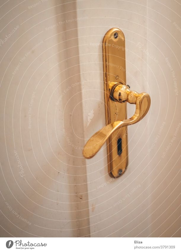 Weiße Tür mit goldenem Türbeschlag. Türklinke und Türschloss. weiß alt Altbau Eingang Schlüsselloch Griff Holztür