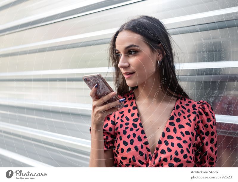 Frau nimmt Sprachnachricht auf Smartphone auf der Straße auf Stimme Nachricht Audio Aufzeichnen benutzend Großstadt soziale Netzwerke jung Metall Wand online