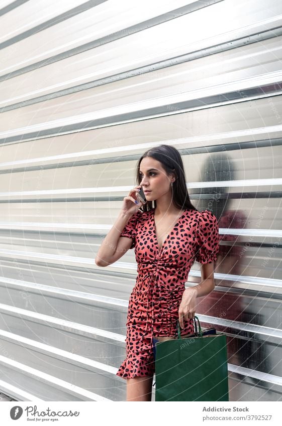 Frau auf Smartphone auf der Straße Stimme Nachricht Audio benutzend Großstadt soziale Netzwerke jung Metall Wand online Apparatur Gerät charmant Handy Talkrunde