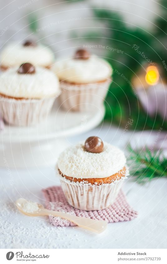 Süße Cupcakes mit Schokoladenkugeln auf dem Tisch süß Dessert Weihnachten Leckerbissen Kokosnuss Schuppen Ball geschmackvoll Veranstaltung Tradition Party