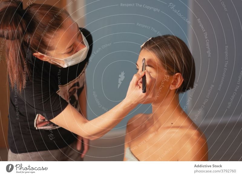 Visagist beim Schminken des Gesichts eines Models Make-up Künstler Fundament Salon Kosmetik charmant vorbereiten Frauen Bürste Pflege Stil Schönheit Glamour