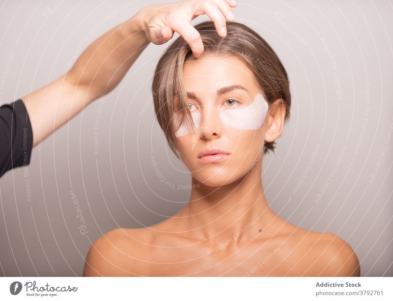 Anonymer Friseur, der die Haare eines weiblichen Modells im Studio einstellt Behaarung ausrichten Atelier vorbereiten Photo-Shooting Vorschein Stil trendy